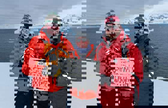 Expedition guests celebrate reaching Antarctica, the world's seventh continent. 