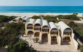 Aerial view of Hotel Escondido, a luxury beachfront eco-hotel with white arched villas on the Oaxaca coast in Mexico. 