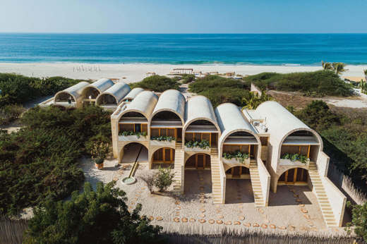Aerial view of Hotel Escondido, a luxury beachfront eco-hotel with white arched villas on the Oaxaca coast in Mexico. 