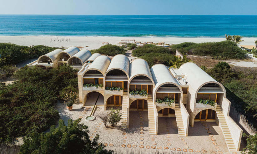 Aerial view of Hotel Escondido, a luxury beachfront eco-hotel with white arched villas on the Oaxaca coast in Mexico. 