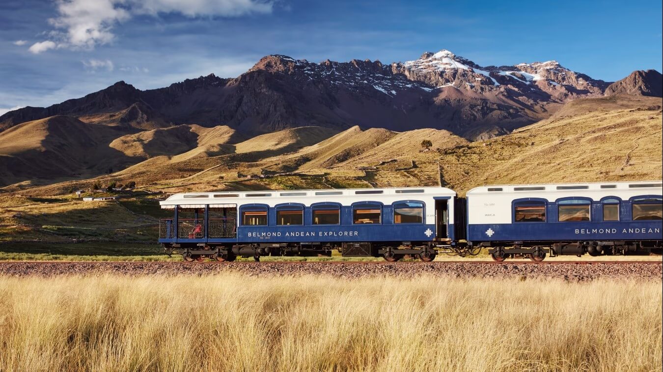 The Belmond Andean Explorer train crossing the high plans of Peru with the Andes in the background. 