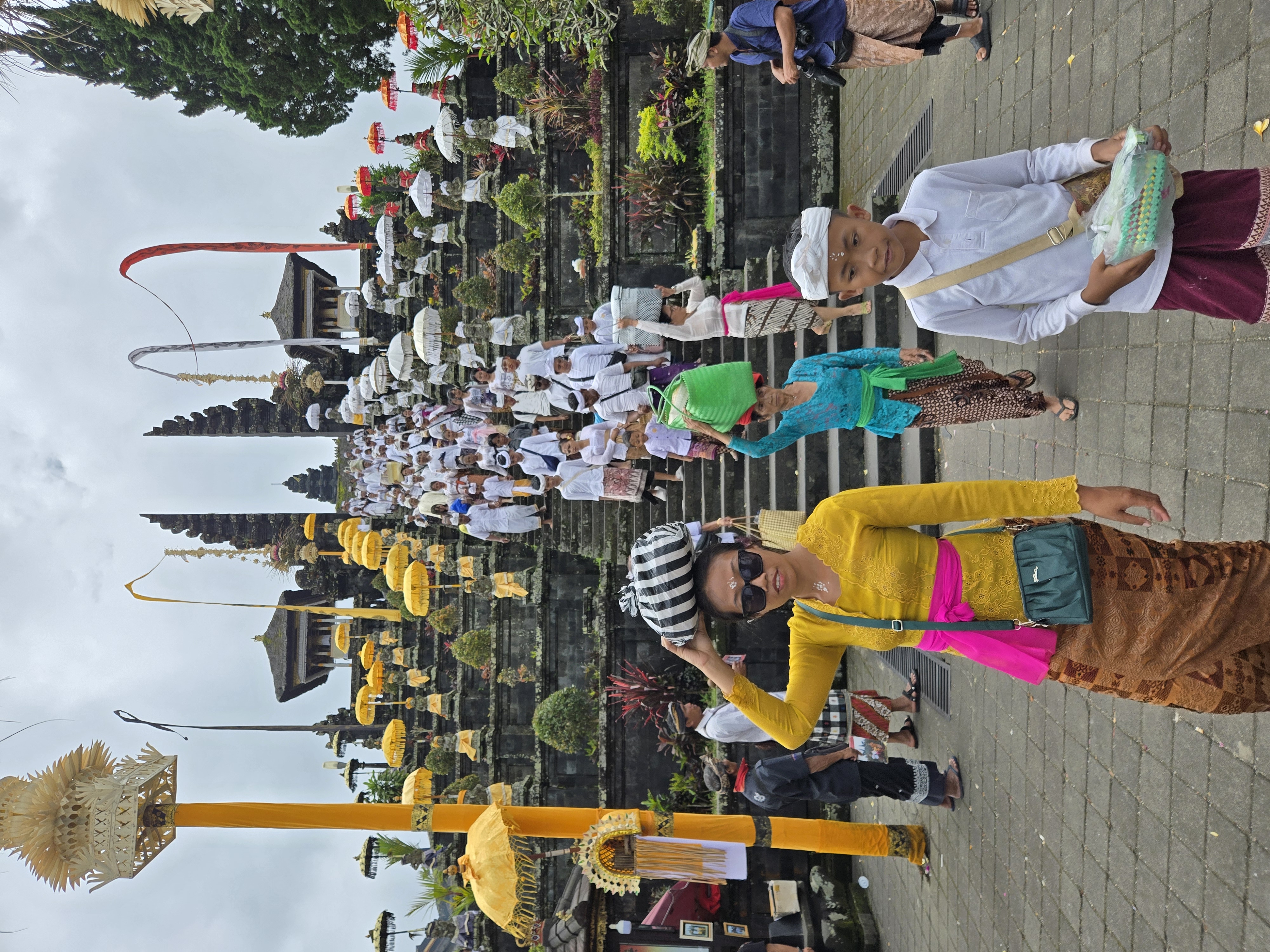 Worshippers in colourful attire ascend the steps of Besakih Temple in Bali during a vibrant Hindu ceremony. 