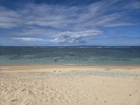 Tranquil waves lap the soft sands of Sanur Beach in Bali, Indonesia. 