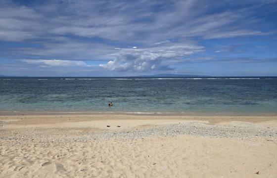 Tranquil waves lap the soft sands of Sanur Beach in Bali, Indonesia. 