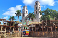 Traditional wooden setup for the Espita Yucatan Feria with the colonial church and palm trees in the background. 