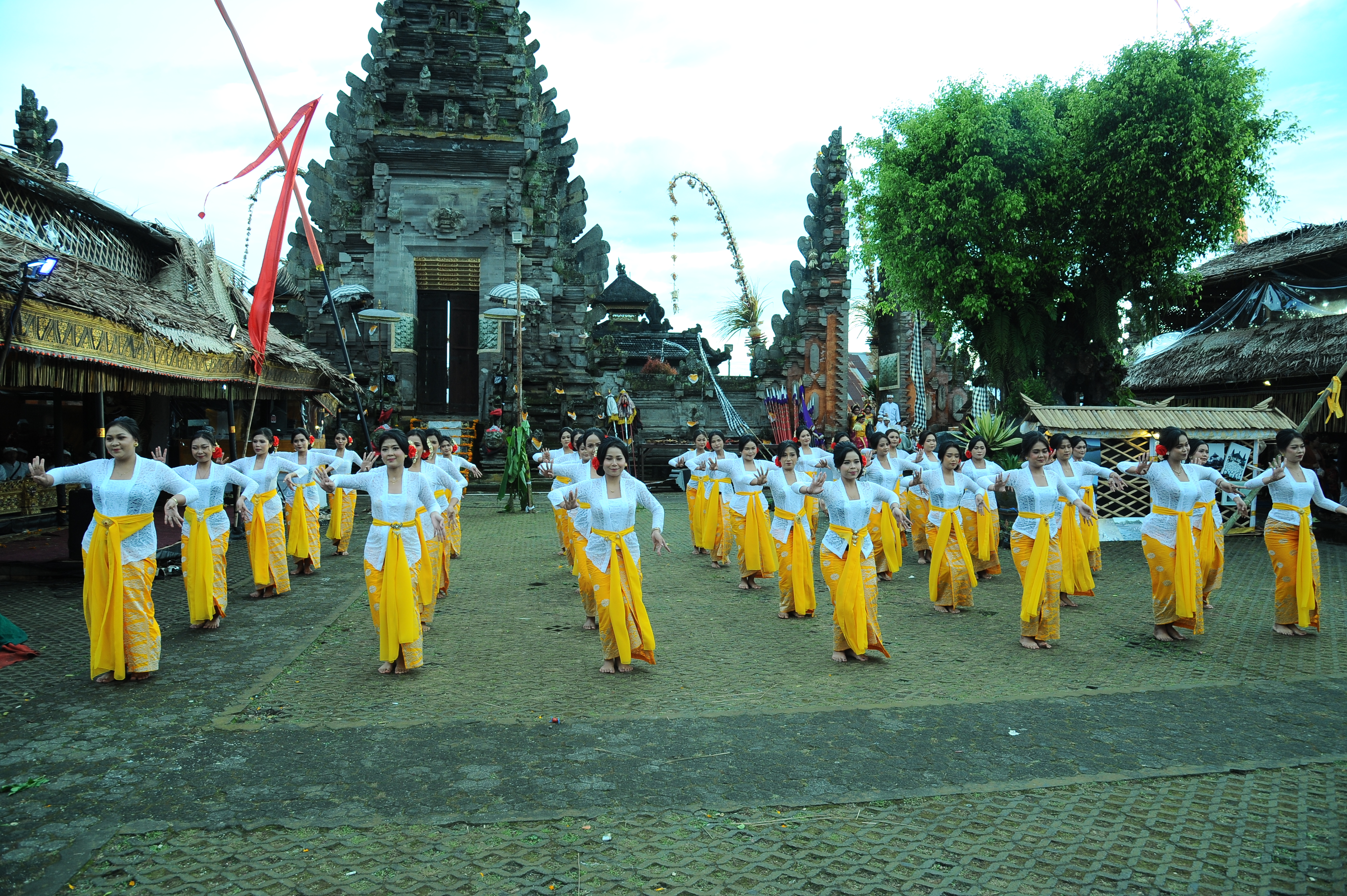 Dozens of Balinese women in yellow sarongs line up for the Galungan festival ceremony in Bali, Indonesia. 