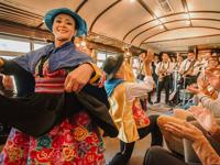 Traditional dancers and live band performing on board the Belmond Hiram Bingham train to Machu Picchu. 