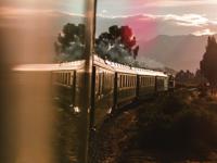 Luxury train journey to Machu Picchu passing through scenic countryside at sunset. 
