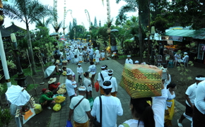 Balinese locals in white attire walk in a ceremonial temple procession in Munduk. 