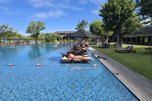 Guests relax beside a sparkling infinity pool at Sperb Beach Resort in Bali, Indonesia. 