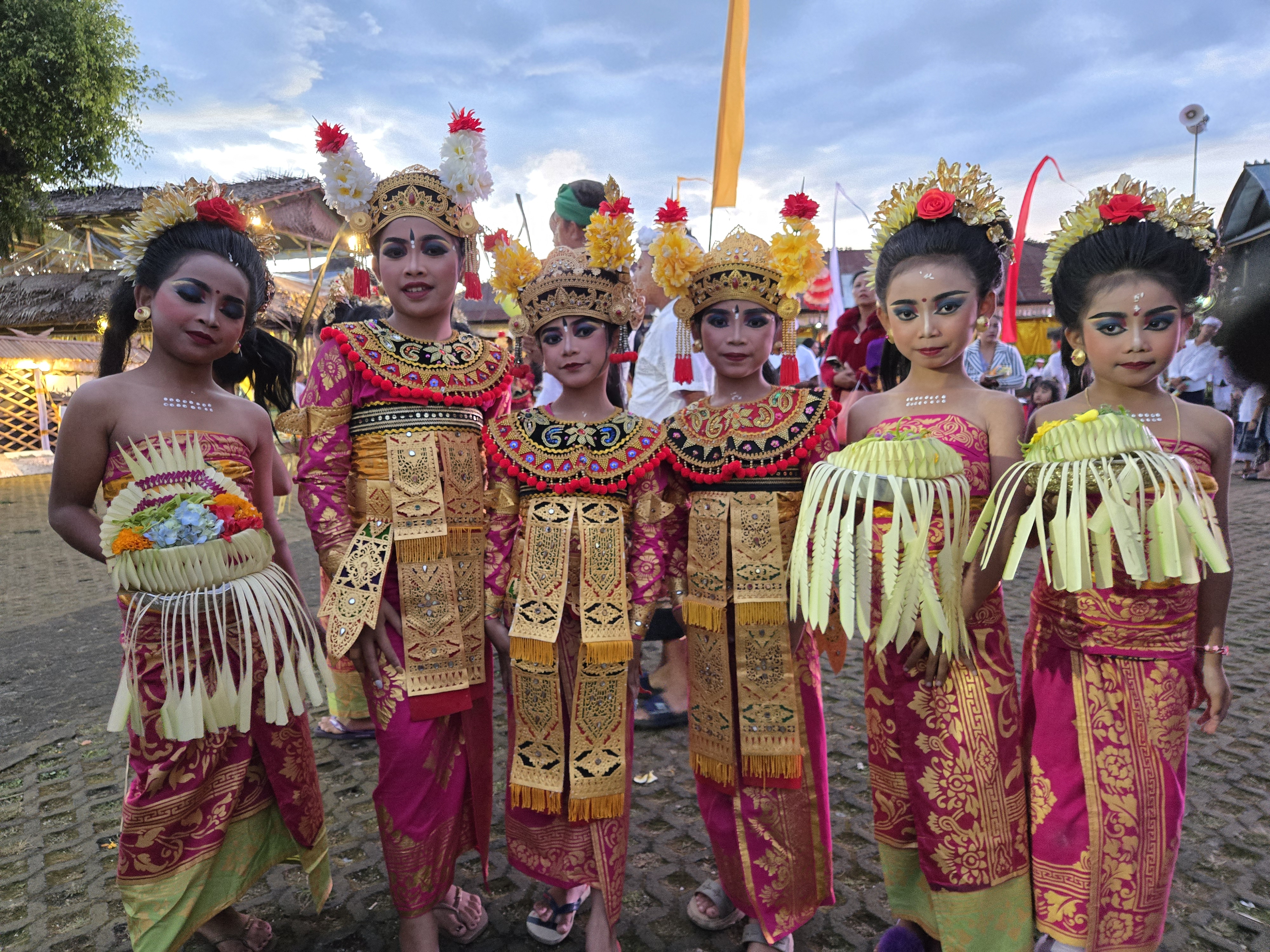 Balinese children dressed in ornate traditional costumes pose before a temple dance ceremony in Bali, Indonesia. 
